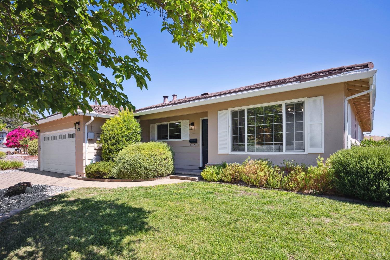 a front view of a house with a garden and plants