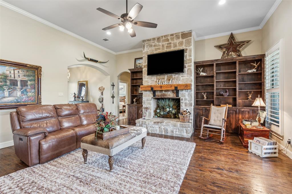 4180 North Smith Road Fate, TX 75087 - Photo 7 of 27 Living room featuring crown molding, a fireplace, dark hardwood / wood-style floors, and ceiling fan