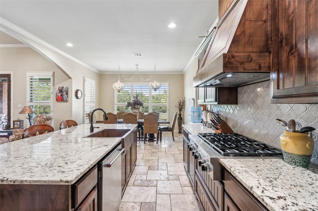 4180 North Smith Road Fate, TX 75087 - Photo 9 of 27 Kitchen with stainless steel dishwasher, premium range hood, light tile patterned flooring, tasteful backsplash, and a chandelier