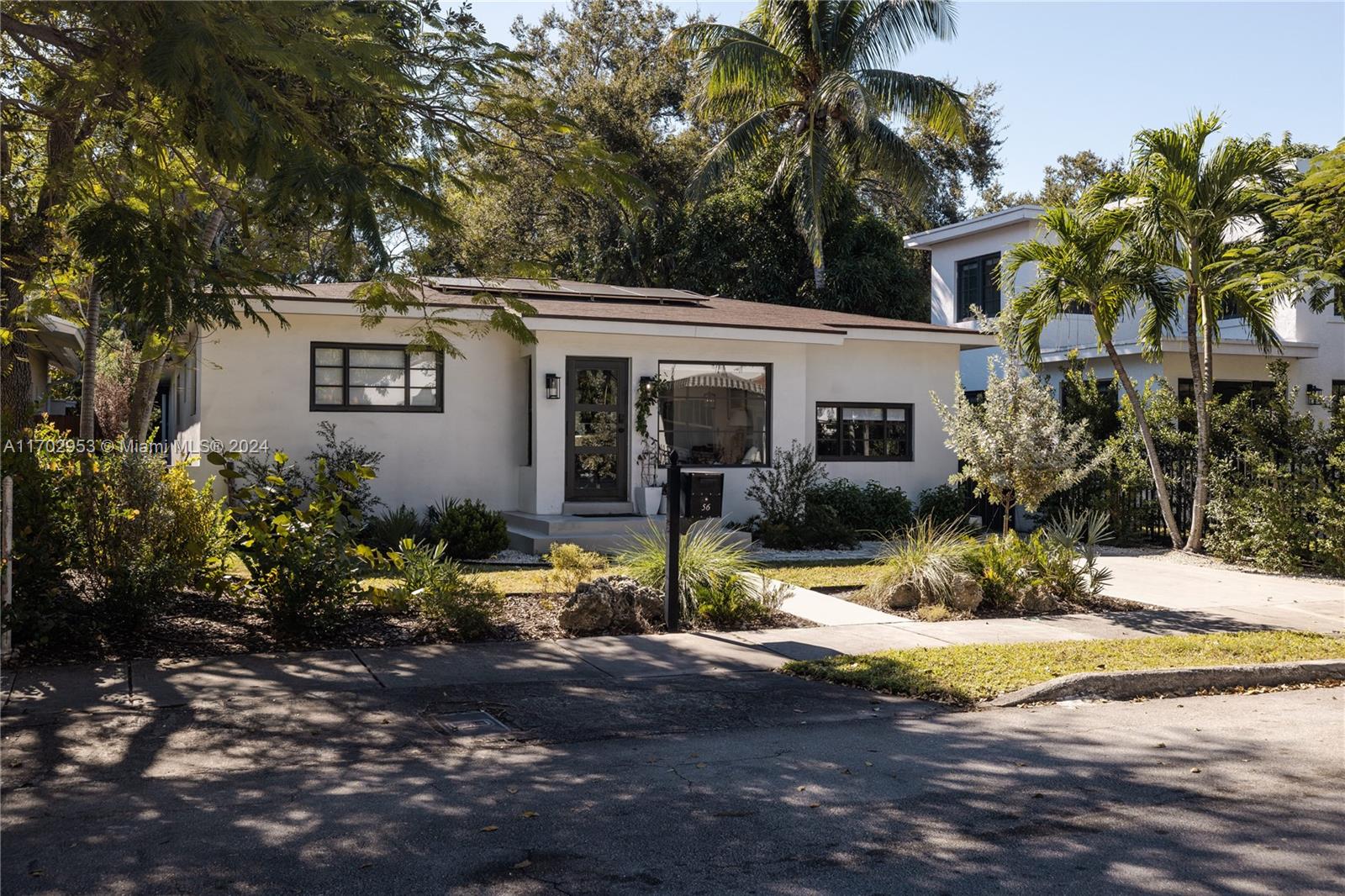 56 Northeast 46th Street Miami, FL 33137 - Photo 26 of 28 a view of a white house with large windows and plants