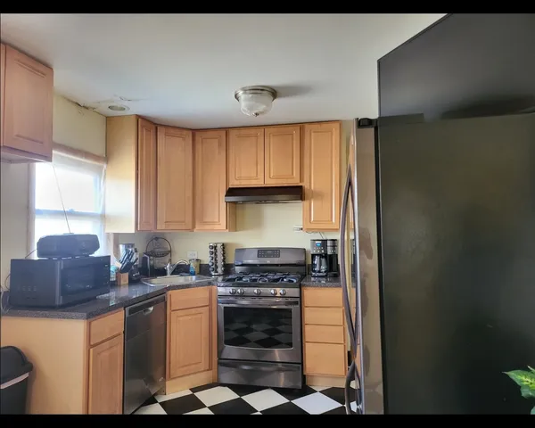 a kitchen with stainless steel appliances granite countertop a stove a sink and a refrigerator