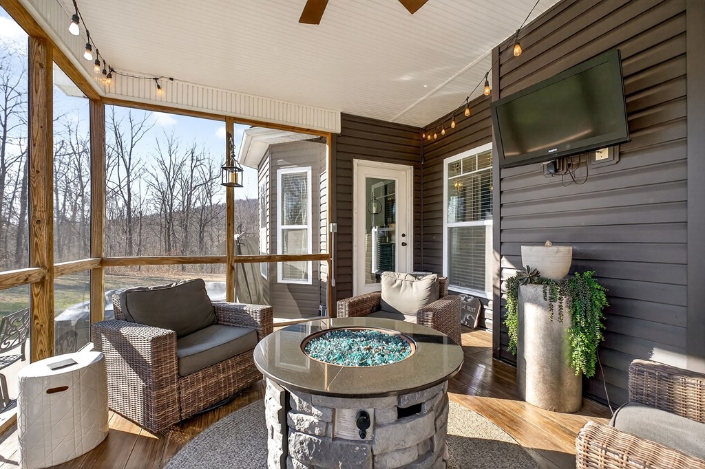 6081 Buck Mountain Road Cookeville, TN 38506 - Photo 32 of 71 a living room with furniture a flat screen tv and a floor to ceiling window