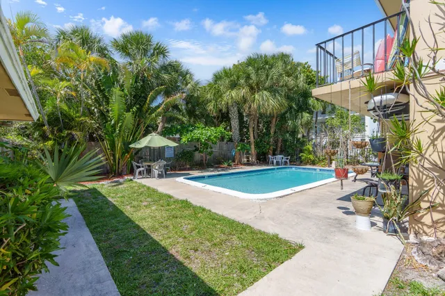 a view of a house with backyard and sitting area