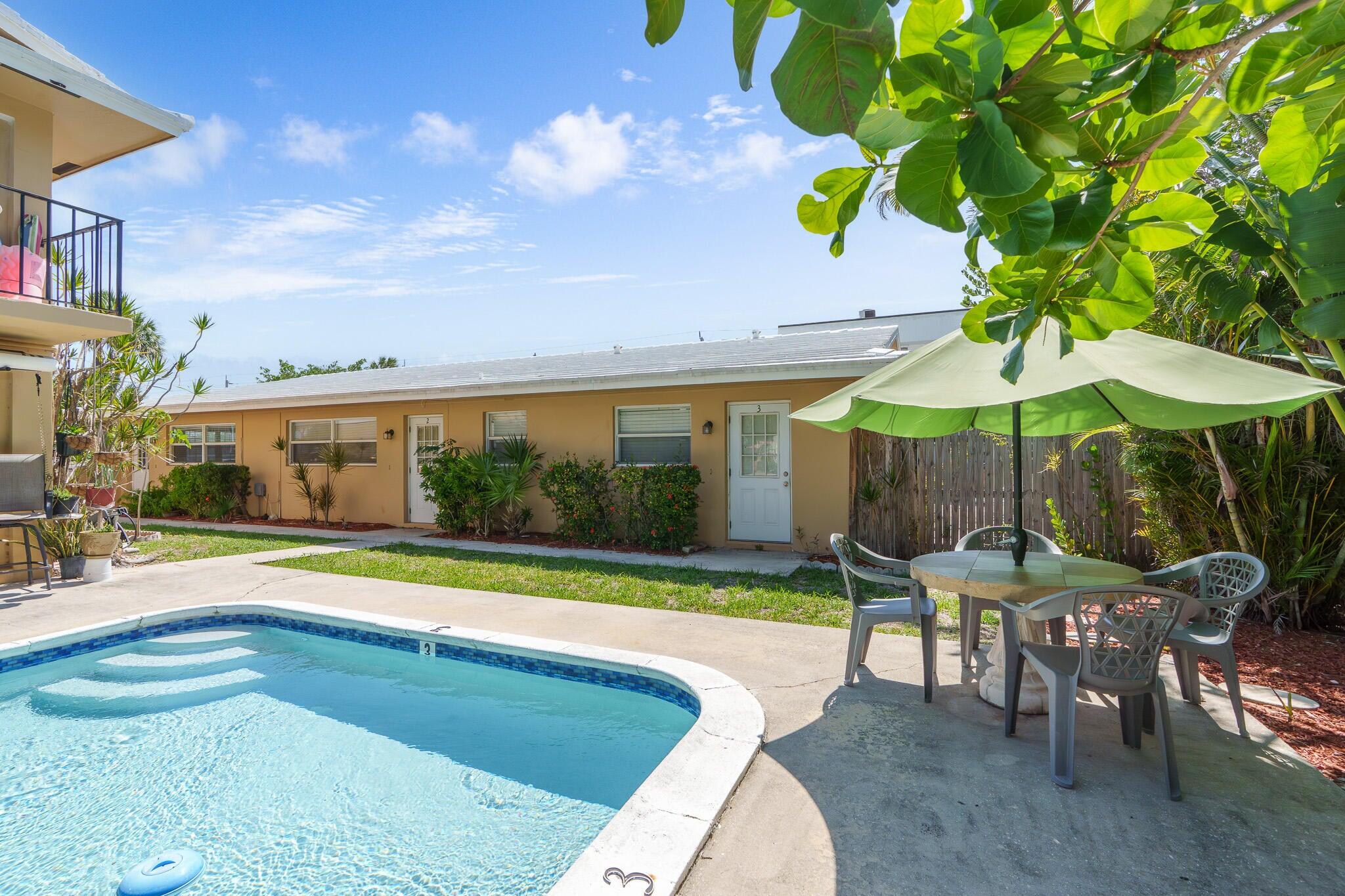 2031 Southeast 5th Street, Unit 8 Deerfield Beach, FL 33441 - Photo 10 of 13 a patio with a table and chairs under an umbrella