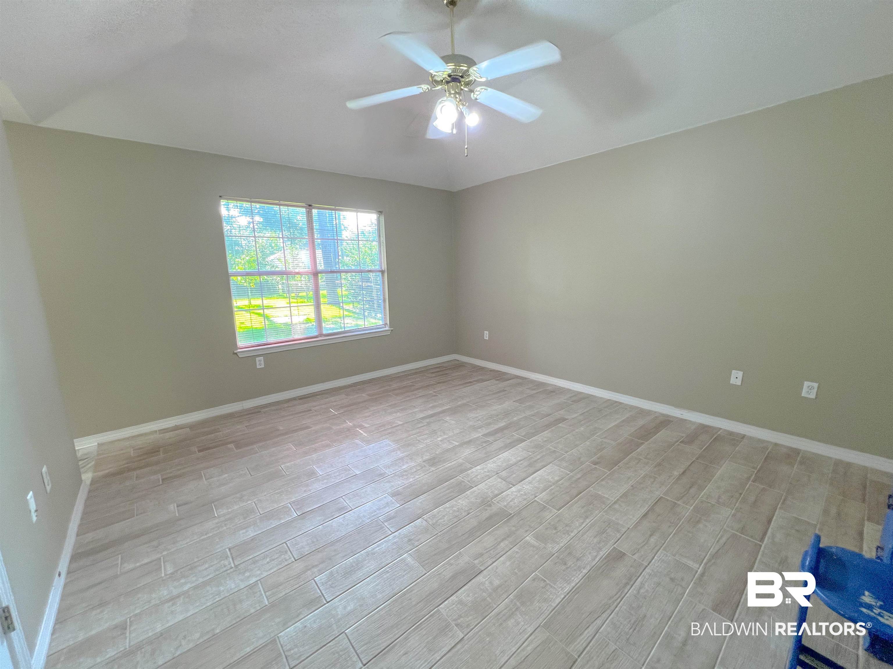 1200 South Juniper Street Foley, AL 36535 - Photo 11 of 23 Spare room with vaulted ceiling, ceiling fan, and light wood-type flooring