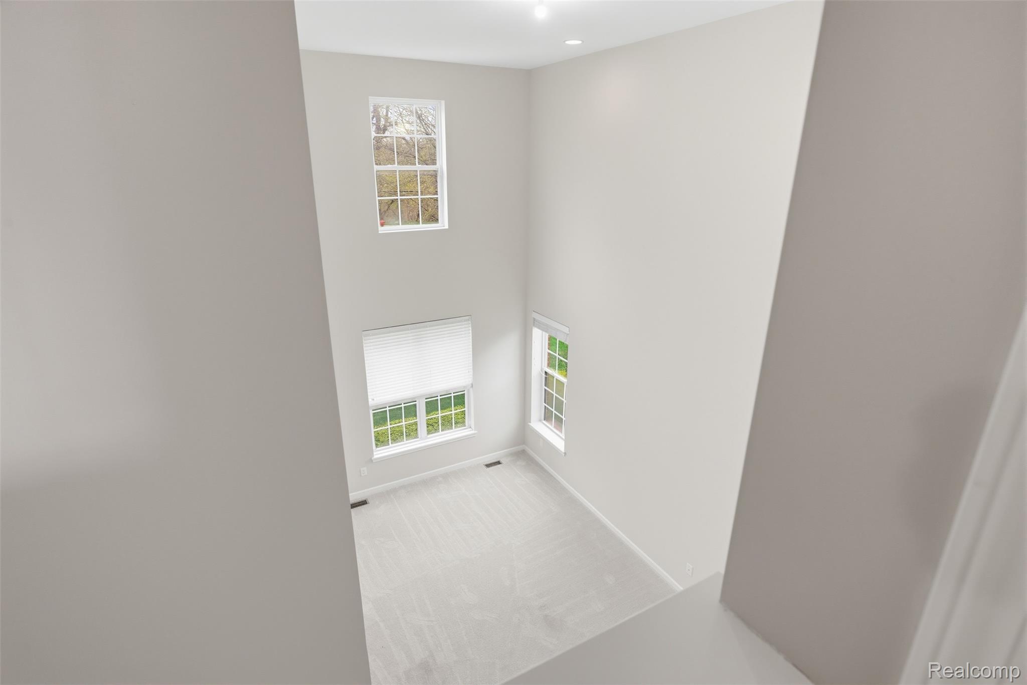 41594 Mitchell Road Novi, MI 48377 - Photo 17 of 35 Empty room with a high ceiling and light carpet