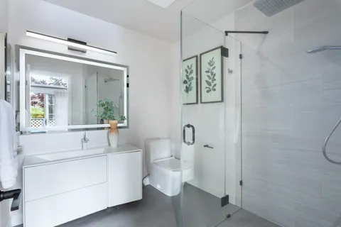 a bathroom with a sink a toilet and shower