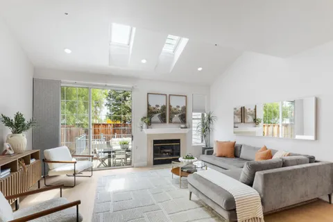 a living room with furniture fireplace and a large window