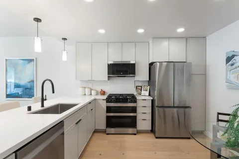a kitchen with stainless steel appliances a refrigerator sink and microwave