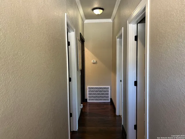 a view of a hallway with wooden floor