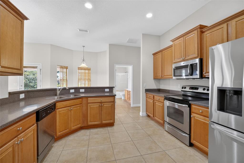 4319 Southwest 63rd Street Ocala, FL 34474 - Photo 9 of 29 a kitchen with stainless steel appliances granite countertop a sink counter space cabinets and a large window
