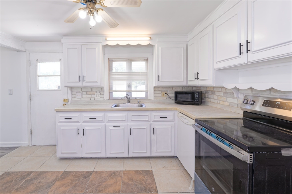 1 Rockland Rd Court Auburn, MA 01501 - Photo 14 of 38 a kitchen with granite countertop white cabinets stainless steel appliances a sink and a window