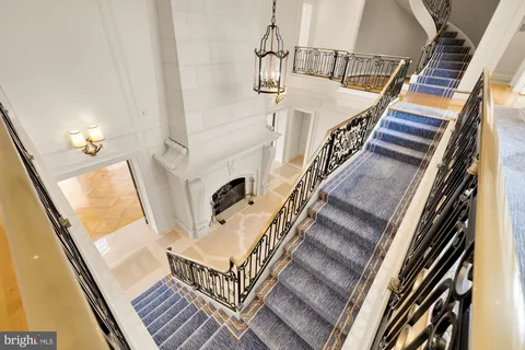 a view of a hallway with wooden floor and staircase