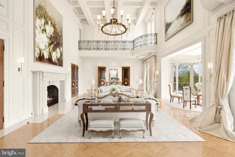 a living room with furniture a fireplace and a chandelier