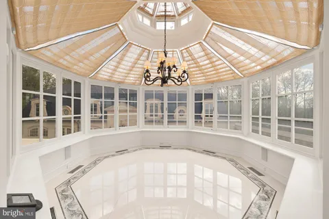 a view of a swimming pool with a yard and large trees