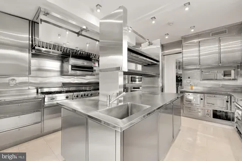 a front view of a building with a garden and plants