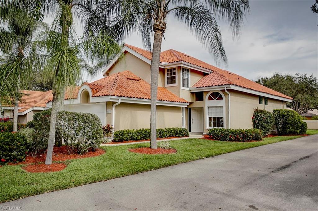 168 Napa Ridge Way Naples, FL 34119 - Photo 1 of 22 a front view of a house with a garden and palm trees