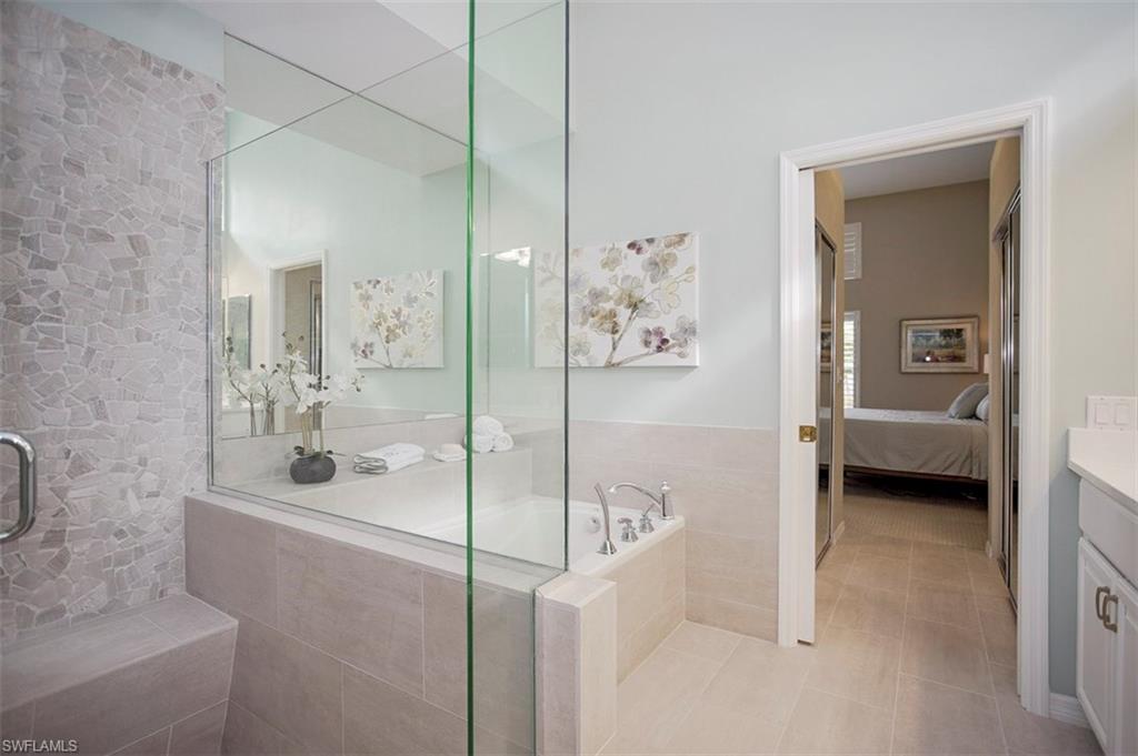 168 Napa Ridge Way Naples, FL 34119 - Photo 11 of 22 a bathroom with a tub sink and mirror