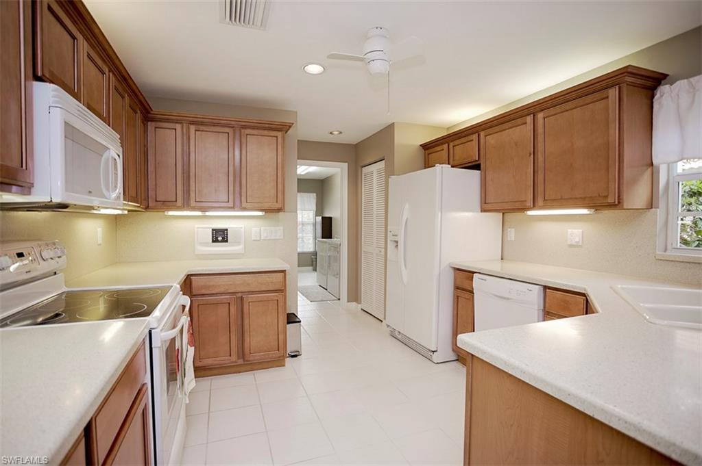 168 Napa Ridge Way Naples, FL 34119 - Photo 14 of 22 a kitchen with a sink a stove a refrigerator a washer and dryer