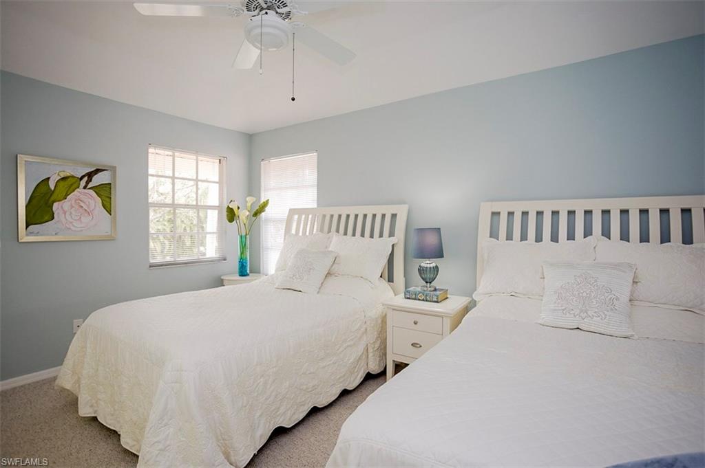 168 Napa Ridge Way Naples, FL 34119 - Photo 18 of 22 a bedroom with a bed and a chandelier