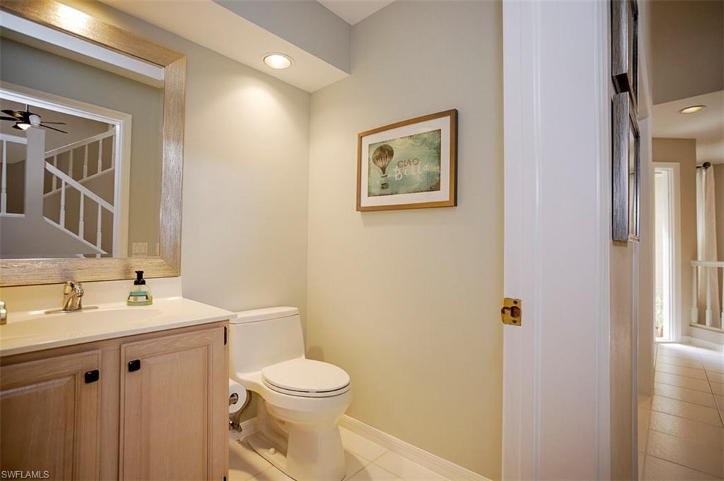 168 Napa Ridge Way Naples, FL 34119 - Photo 6 of 22 a bathroom with a toilet a sink and mirror