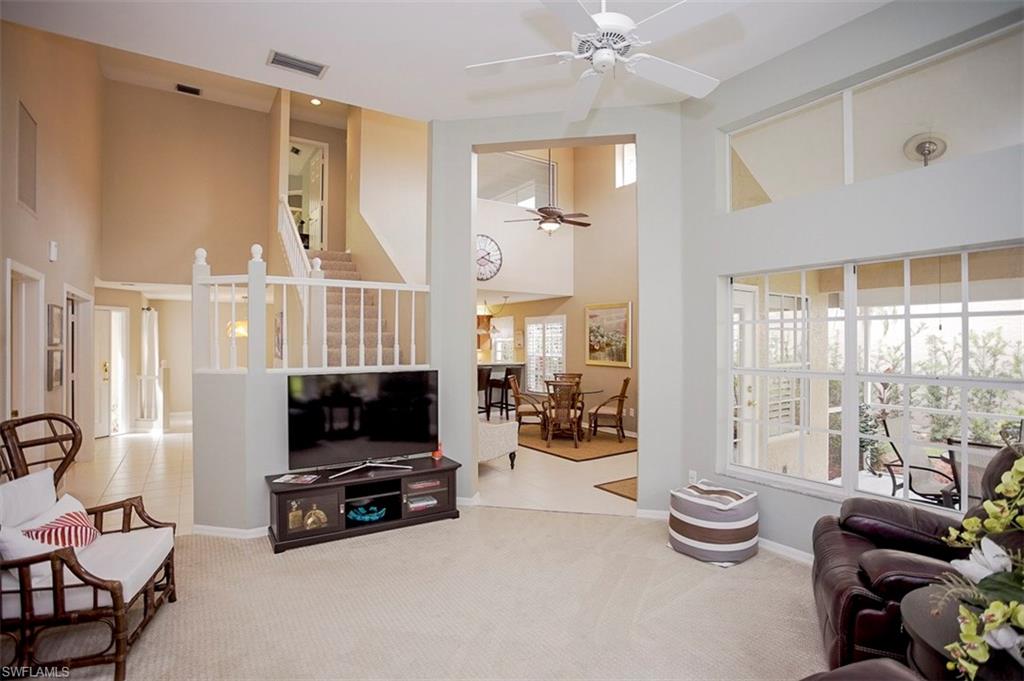 168 Napa Ridge Way Naples, FL 34119 - Photo 8 of 22 a living room with furniture a flat screen tv and floor to ceiling window
