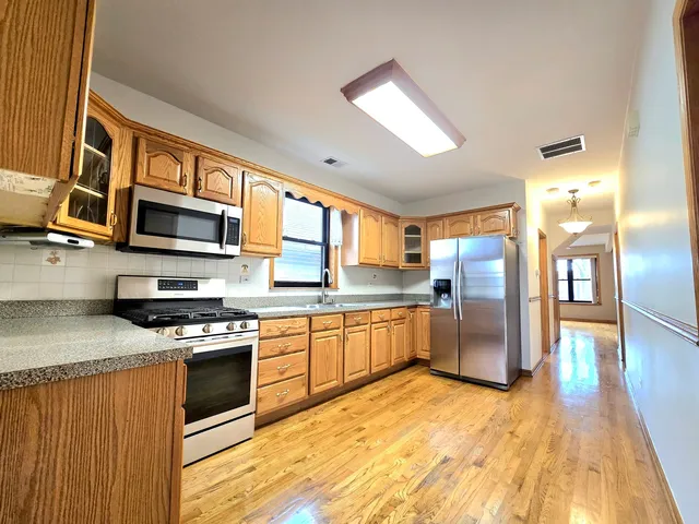 a kitchen with stainless steel appliances granite countertop a stove refrigerator sink and microwave