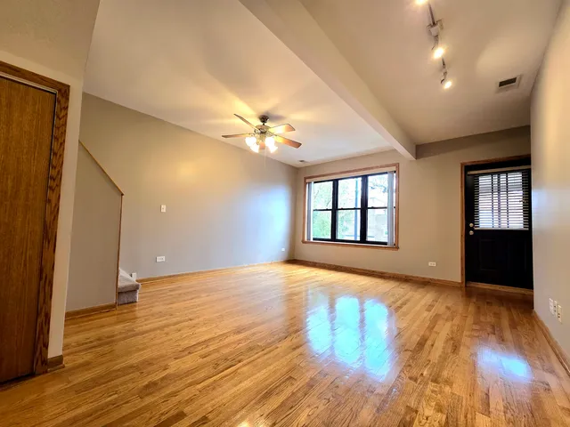 a view of an empty room with window and wooden floor