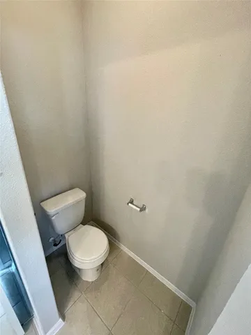 a white toilet sitting next to a white wall