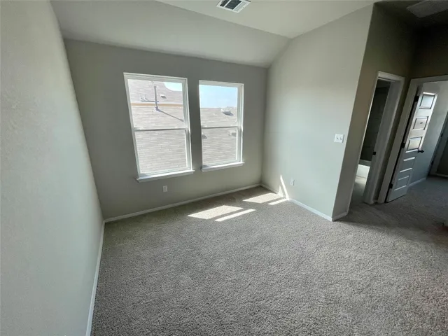 an empty room with a fireplace and windows