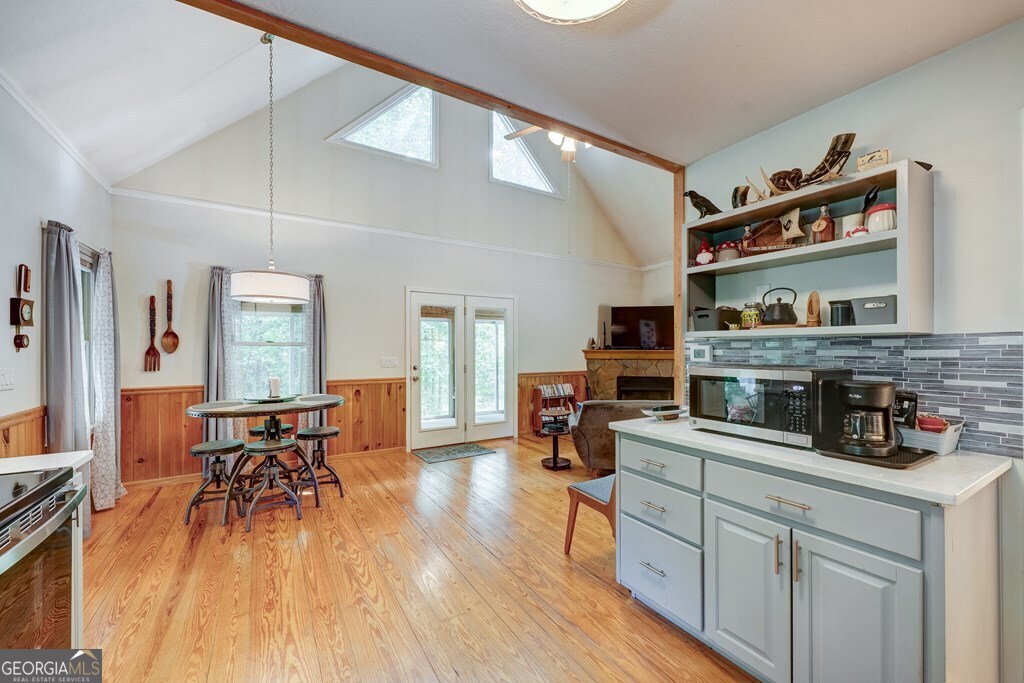 154 Rhapsody Circle Ellijay, GA 30540 - Photo 14 of 64 a kitchen with stainless steel appliances granite countertop a stove top oven a sink a dining table and chairs with wooden floor