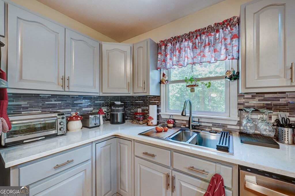 154 Rhapsody Circle Ellijay, GA 30540 - Photo 17 of 64 a kitchen with stainless steel appliances granite countertop a sink a counter space and cabinets