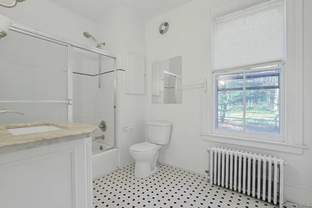 a bathroom with a sink toilet a shower and a window
