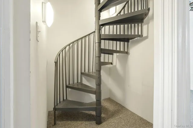 a view of staircase with railing and a window