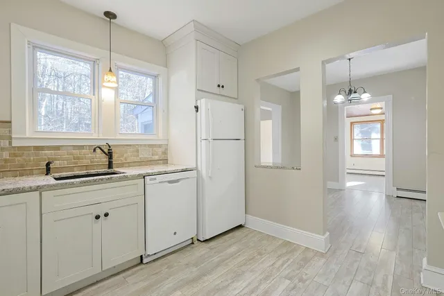 a kitchen with a refrigerator sink and cabinets