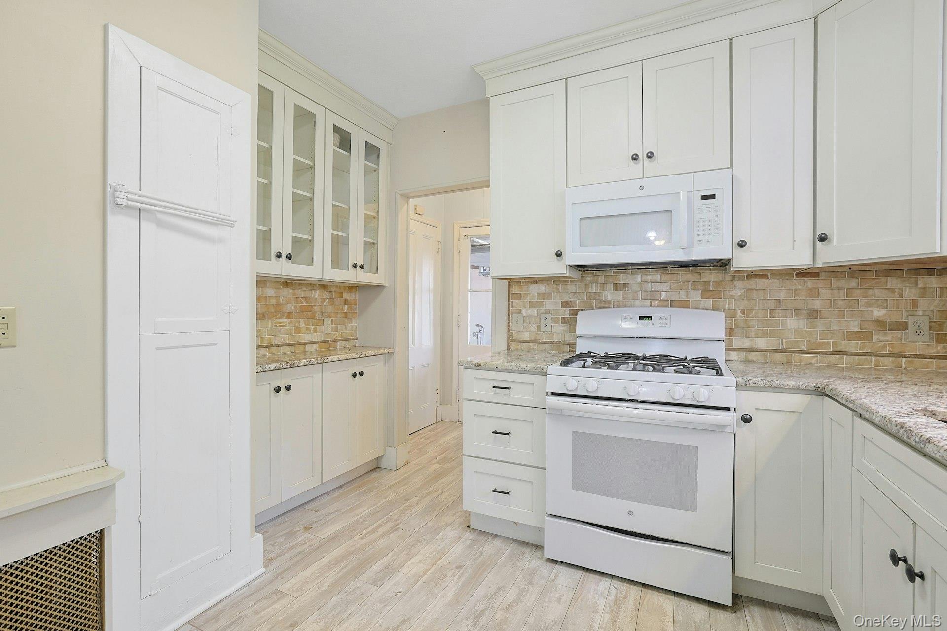 46 Mile Road Montebello, NY 10901 - Photo 3 of 27 a kitchen with white cabinets and white appliances
