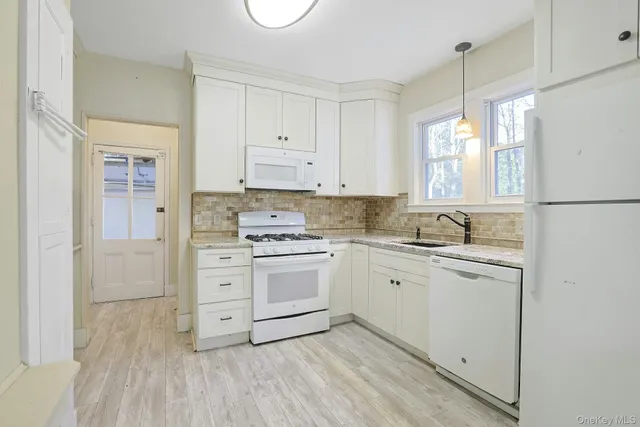 a kitchen with granite countertop white cabinets and white appliances