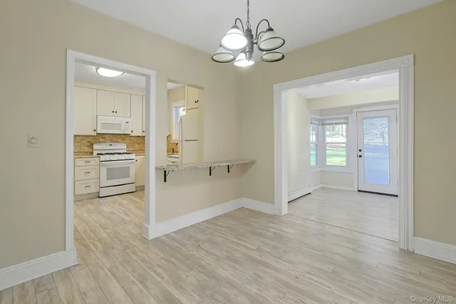 a view of a kitchen with wooden floor and a refrigerator