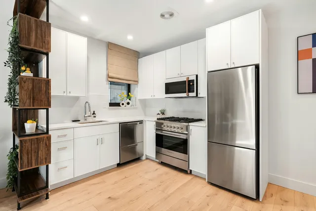 a kitchen with stainless steel appliances a refrigerator sink and stove