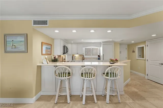 a kitchen with stainless steel appliances granite countertop a sink a stove a dining table and chairs