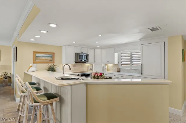 a kitchen with sink a microwave and cabinets