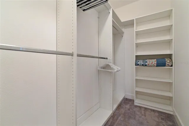 a view of walk in closet with empty racks