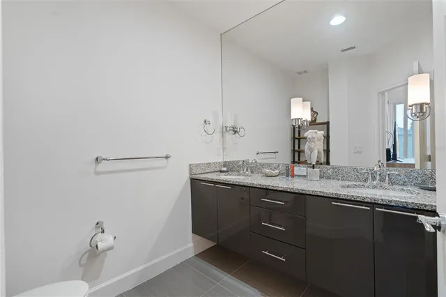 a bathroom with a granite countertop sink a toilet and a mirror