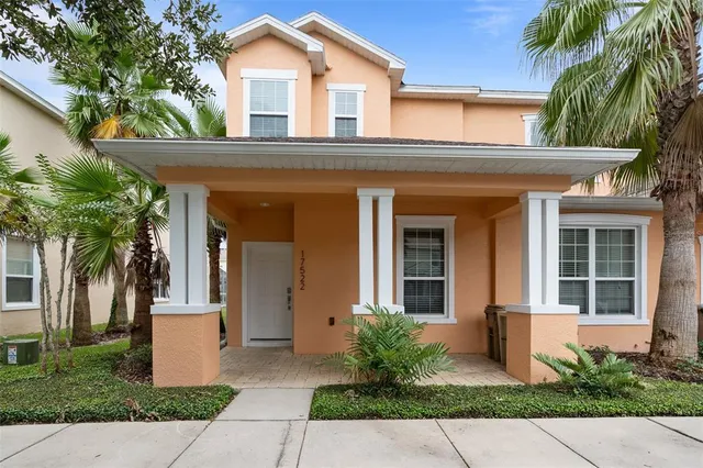 a front view of a house with a yard and potted plants