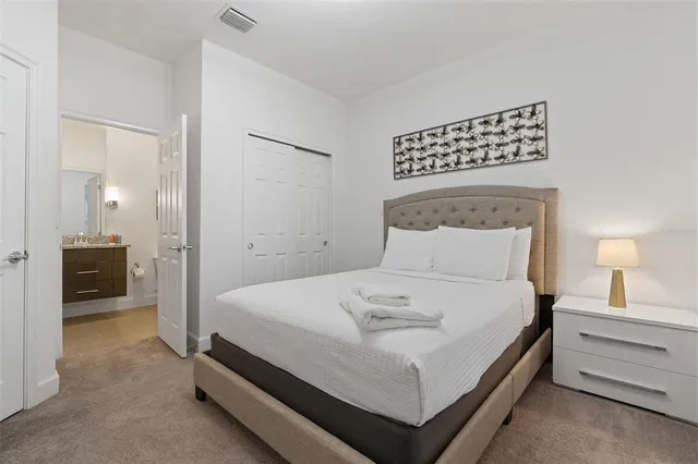 a bedroom with a bed and a night stand