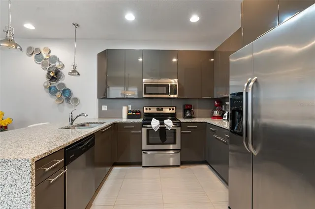 a kitchen with stainless steel appliances granite countertop a sink and a refrigerator