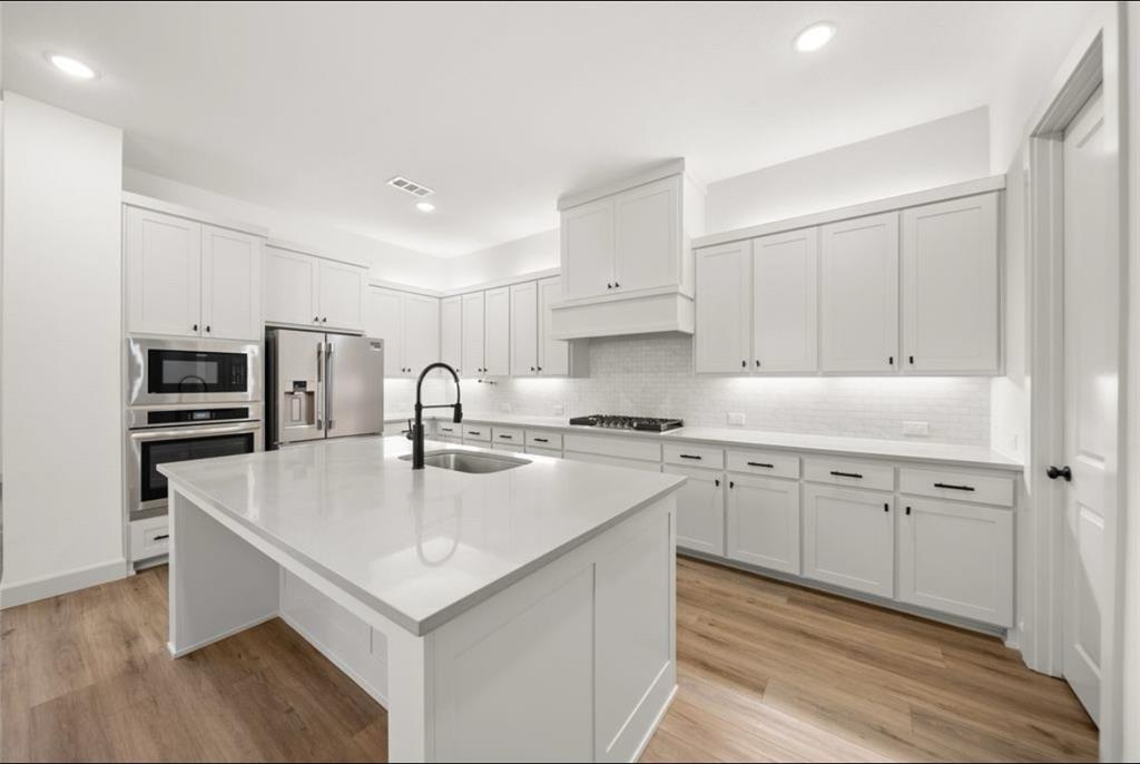 a kitchen with stainless steel appliances granite countertop a sink stove and refrigerator