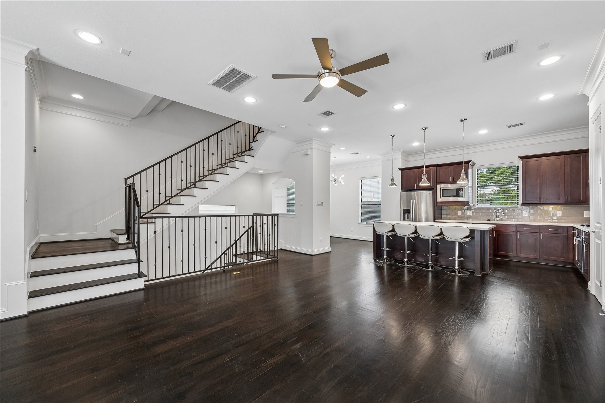 734 West 20th Street, Unit A Houston, TX 77008 - Photo 9 of 23 Second-floor living offers a bright, airy layout w/ rich hardwood floors, crown molding & recessed lighting, complemented by a ceiling fan & convenient half bath. Floor plugs add flexibility for furniture placement.