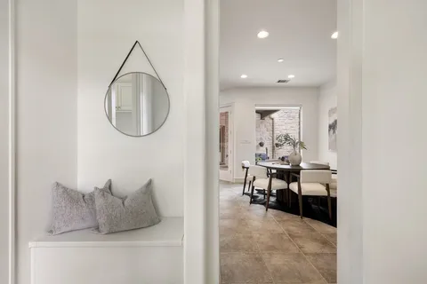 a living room with furniture a mirror and a table