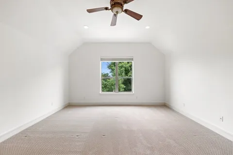 an empty room with a window and a ceiling fan